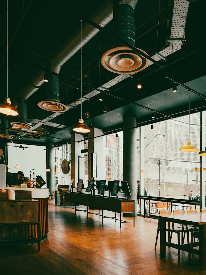 A modern, ambient café interior with industrial design elements in an urban setting.