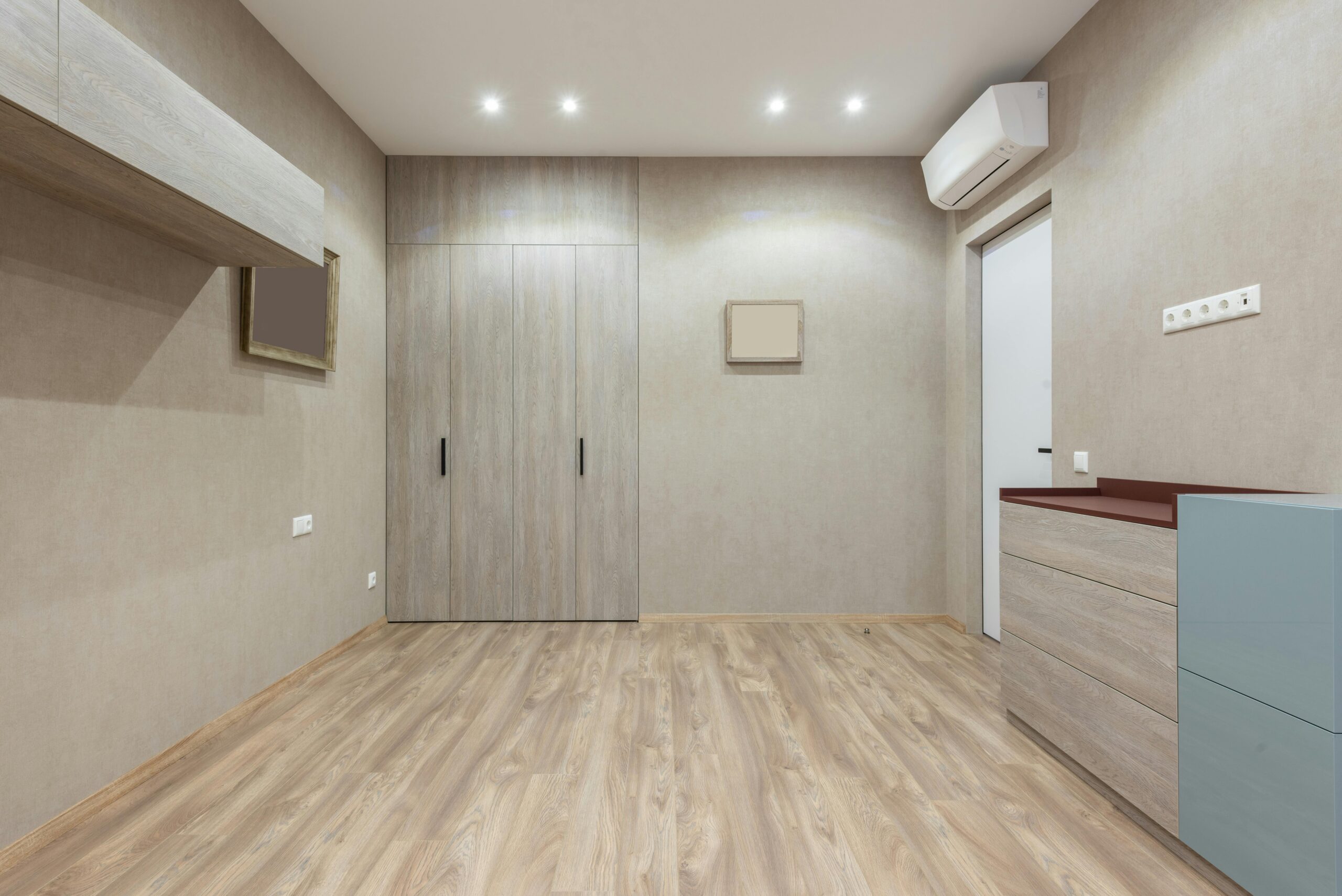 Interior of modern light room with minimalist design and cupboard placed near closet at wall with mirror in contemporary apartment