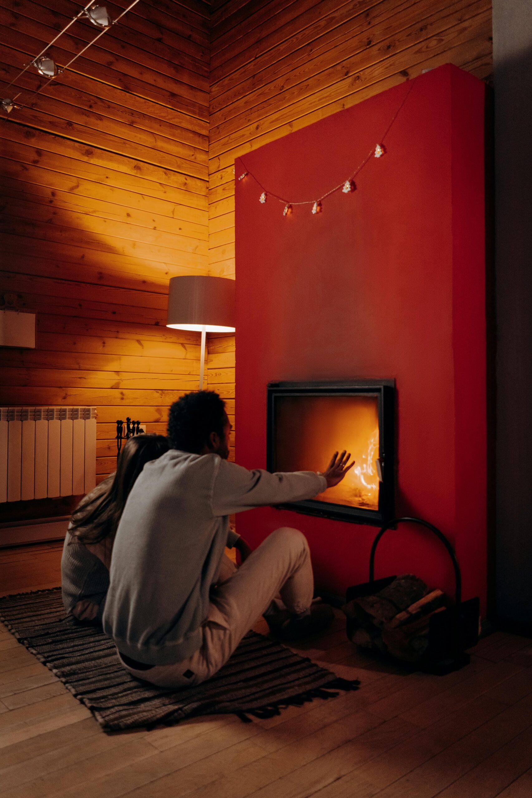 A couple enjoys warmth and relaxation by a cozy fireplace indoors during winter.